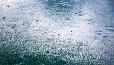 A blue-tinged image of rain hitting the ground